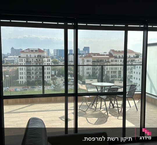 מרפסת עם דלתות זכוכית ונוף לעיר